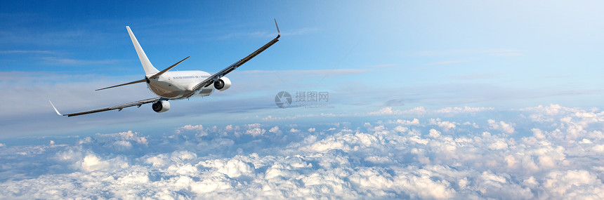 飞机在蓝天白云中飞行的全景图片