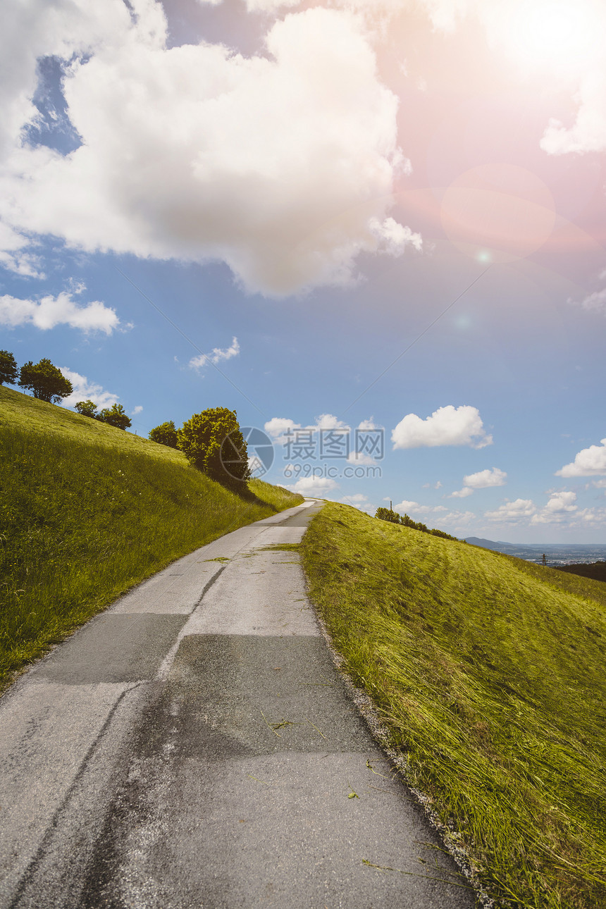 古德林山地貌陡峭的沥青山路绿草地和蓝天云图片