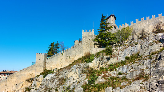 梅利诺尼古老的圣马利诺城墙在岩石上背景