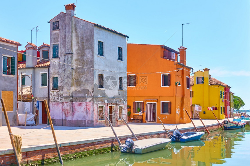 在意大利威尼斯的夏日阳光明媚子里在布拉诺岛的运河上有船只和多彩房屋图片