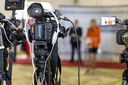 电视公告用摄像机拍记者招待会或新闻简报背景