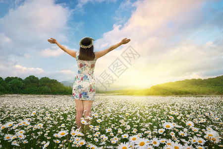 卡莫米里泉花的草地女孩伸手向太阳出来快乐的情感信仰和概念场景图片