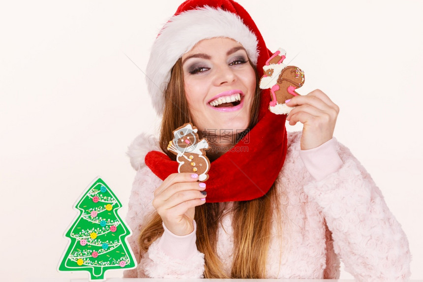 穿着红帽的妇女与姜饼干玩耍小雪人和克萨斯欢乐女孩等待圣诞节日配着姜饼干的圣达克萨斯妇女帽子圣诞快乐女孩图片