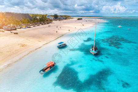热带海岸的渔船空中观察日出时沙滩非洲桑给巴尔暑假船游艇清蓝水绿棕榈树的风景背景图片