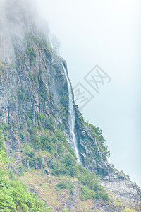 山上瀑布雾雨日美丽的绿色夏季风景旅行和游山地雾日挪威的瀑布图片