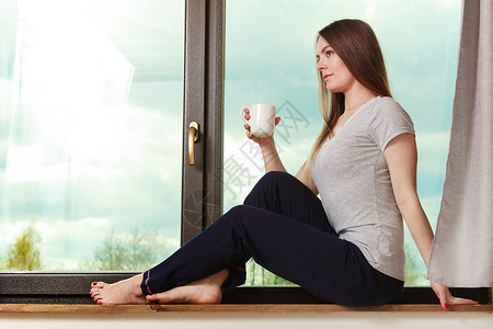 坐在阳台旁边喝咖啡的女孩图片