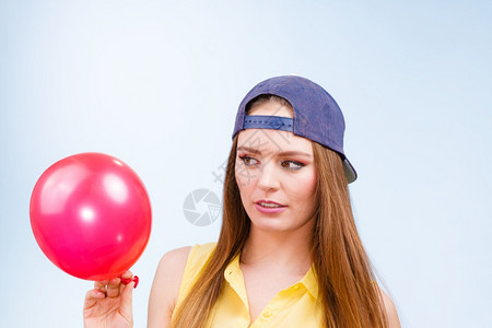 穿牛仔帽的年轻女人拿着红色气球穿的年轻女孩图片