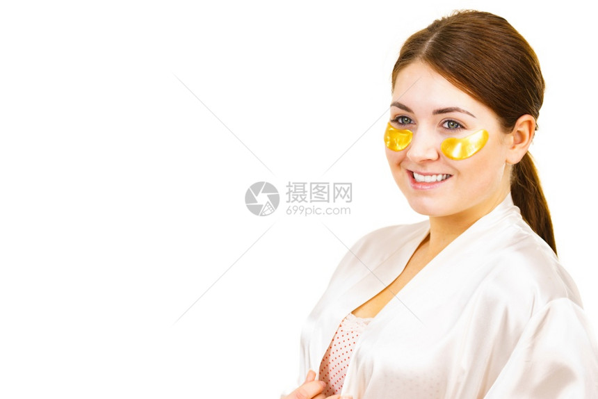 女在眼皮下白色上涂金的椰子膜面罩除去皱纹黑暗圈女孩照顾眼睛周围的精细皮肤美容治疗女在眼皮下涂上金色的斑点女在眼皮下涂上金色图片