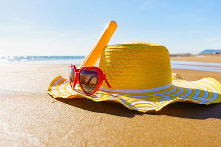 红太阳镜黄草帽和沙滩防晒霜奶油瓶夏天和假日图片