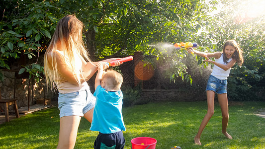 家庭在夏季户外玩耍和乐快的儿童在夏季玩水和花园房子玩耍软管高清图片素材