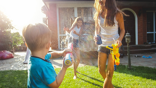 3岁的幼儿男孩在家庭后院用玩具泼水;夏季儿童在户外玩耍和乐;3岁的幼儿男孩在家庭后院用塑料玩具泼水;夏季儿童在户外玩耍和乐。晴朗的高清图片素材