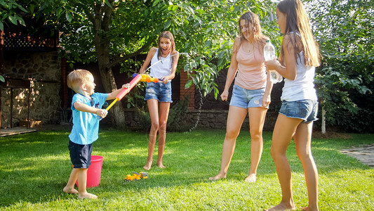 有趣的是在炎热阳光天家庭快乐儿童玩水微笑高清图片素材
