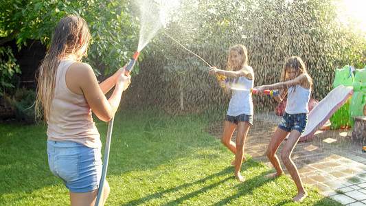 喜笑家庭与孩子们在热暑日玩得开心的美丽照片他们有水和花园龙头家庭在夏季玩耍和户外乐喜笑家庭与孩子们在热暑日玩得开心的美丽形象他们草高清图片素材