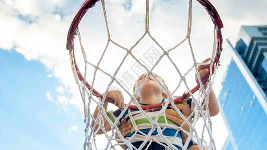 奋斗素材网男孩在篮球网环上玩耍背景