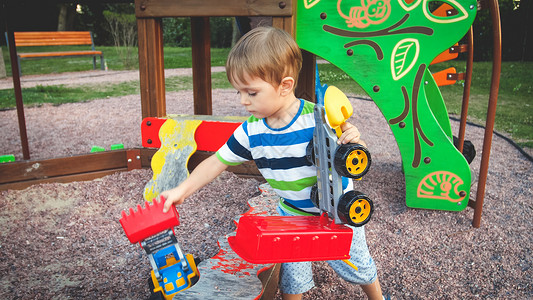 在公园玩玩具卡车的男孩图片
