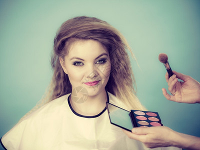 化妆和美容艺术家在女检查时使用刷粉红色的彩染用不同的彩调双蓝化妆艺术家在女检查时使用刷粉红色的彩染背景图片