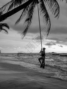 黑色和白照片感年轻女人在海边的子上摇摆黑和白色照片图片