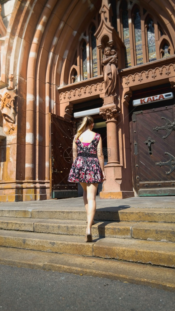 身穿短裙的年轻女子站在欧洲城天主教大堂的旧石头楼梯上身着短裙的年轻美女站在欧洲城天主教大堂的旧石头楼梯上图片