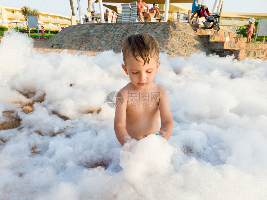 在海边迪斯科派对上小孩男的有趣照片在沙滩迪斯科派对上被肥皂乐覆盖在中图片
