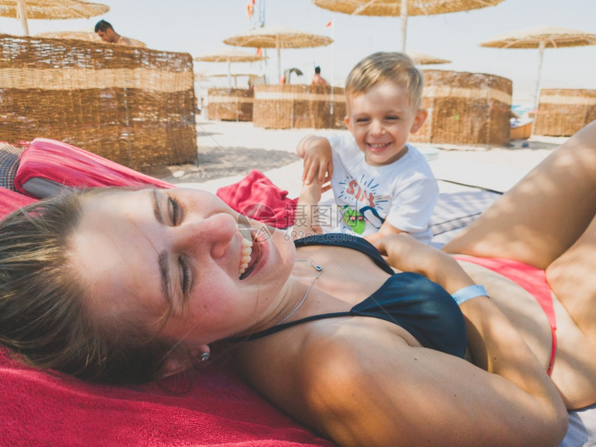 3岁男孩的肖像在海滩上哭啼地躺在太阳床上家庭在暑假期间沙滩上放松和享受美好时光3岁可爱男孩的肖像在海滩上哭泣和啼暑假期间家庭放松图片