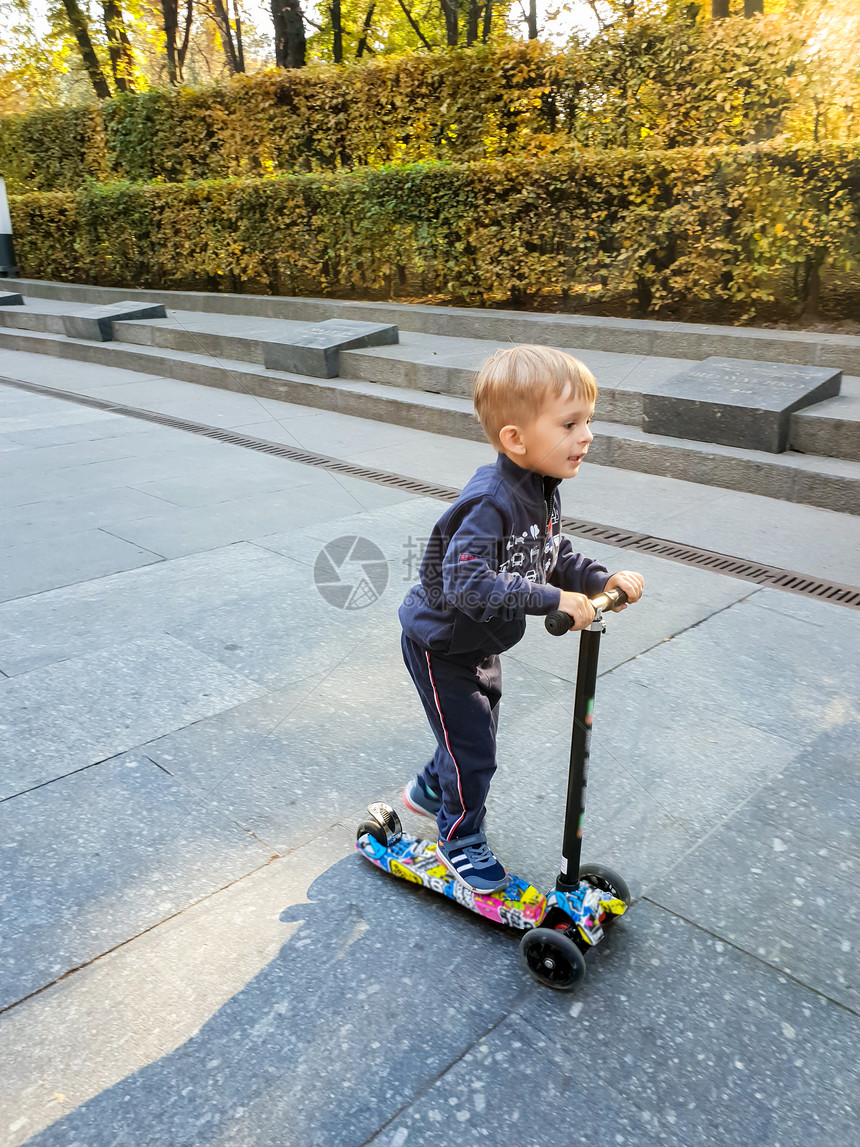 小男孩在公园里玩滑板车图片