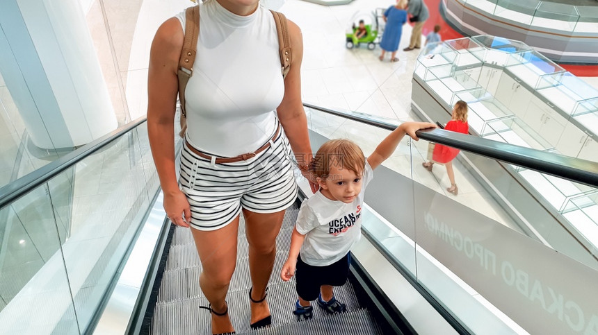 照片来自小孩男在购物中心或机场终点站的扶梯上手抱着母亲图片