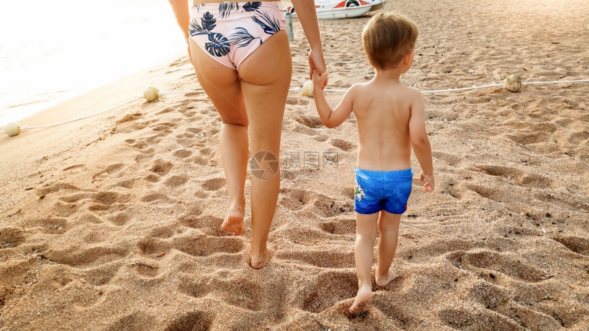 喜笑的3岁幼儿男孩在日落时沙滩上散步和放松的美丽照片家庭在夏季海滩度假期间有愉快的时光喜笑的3岁幼儿男孩在日落时沙滩上散步和放松图片