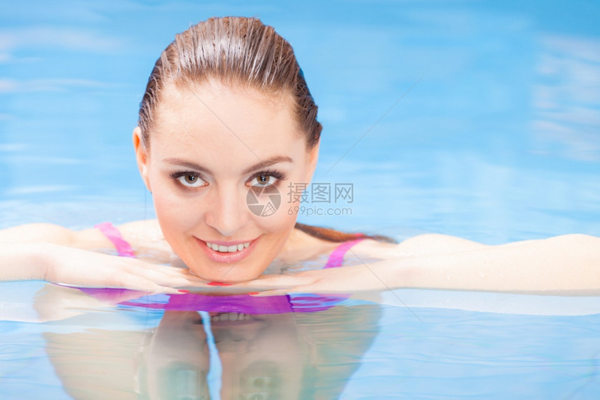 放松温泉酒店度假村概念迷人的女子在游泳池玩得开心享受水游泳池的水图片