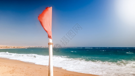 红色警示旗在海上的强风下飘动背景