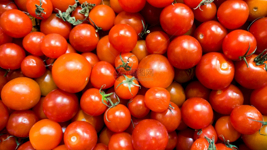 蔬菜商店柜台的许多红小樱桃番茄的宏图新鲜成熟蔬菜的质地或模式图片