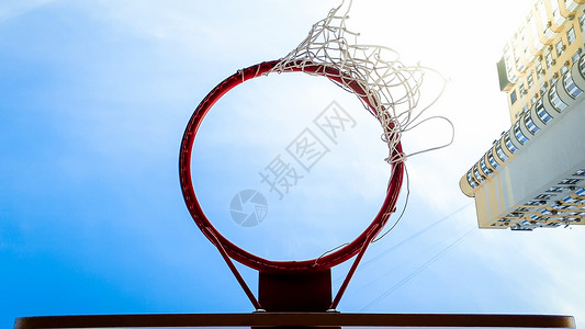 网盾蓝天和城市居住区高楼对蓝天和使用网的篮球环近视照片背景