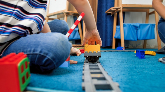 4岁男孩坐在地毯上玩具火车图片