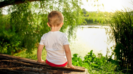 小孩男坐在湖边的村里看着太阳落下小孩男坐在湖边的村里看着太阳落下图片
