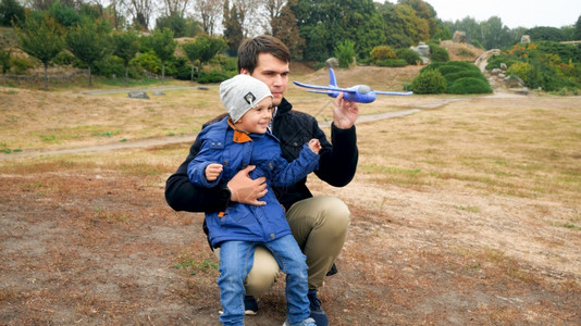 小男孩和父亲在田里玩飞机模型图片