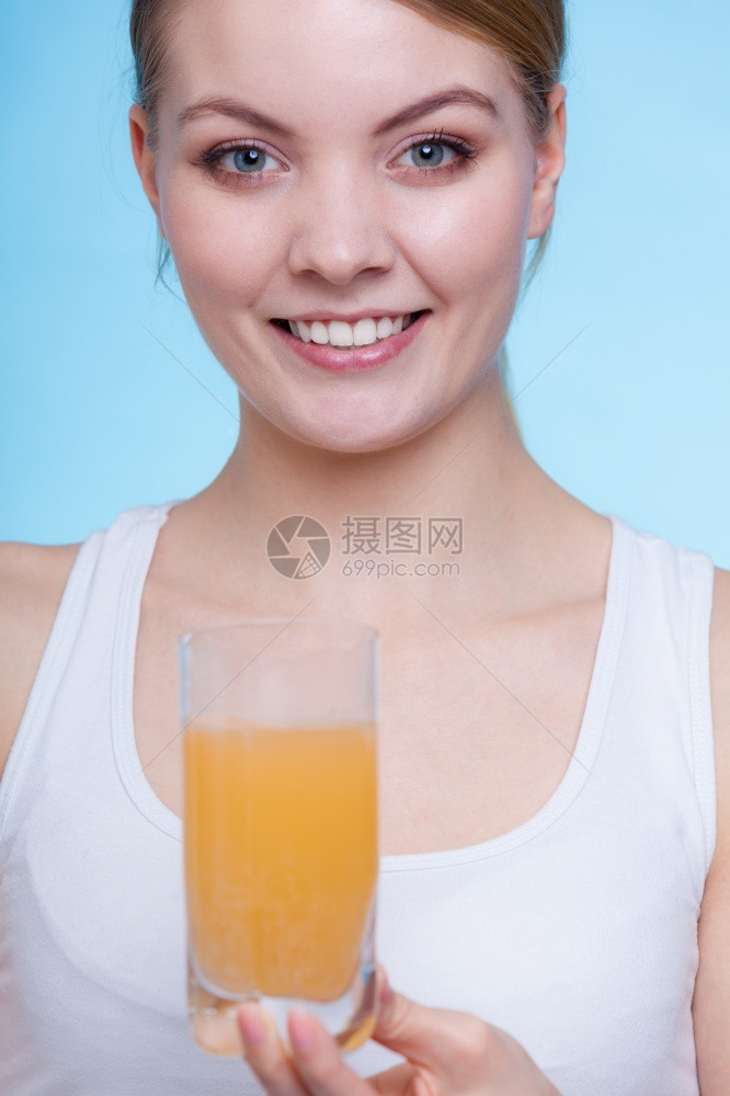 维他命健康药品妇女用橙色口味维生素矿物质补充片在水中溶解的含玻璃妇女蓝底照制工作室含玻璃水和黄片的妇女含玻璃水和黄片图片