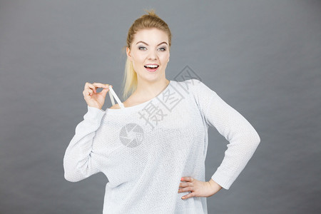 女人用毛衣绑着胸罩带刻薄的概念灰色背景女人用胸罩带着图片