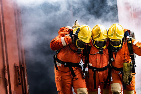 亚洲消防员从燃烧的建筑中救出他们的团队同事从故和公共服务概念中救出消防员的安全救援背景