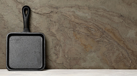 生锈石背景上的铁板空复制文本设计元素的空间木制厨房桌上的铁板图片