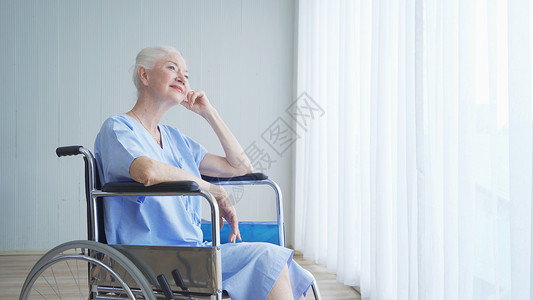 患有残疾的老年妇女在医院病房的轮椅上享受医疗保健概念下的医疗和护理图片