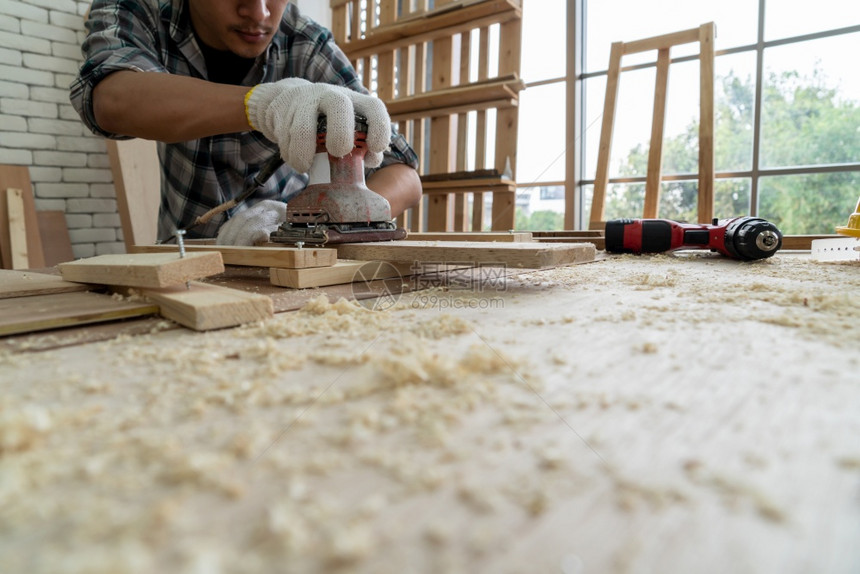 在生产建筑材料或木制家具的讲习班上从事木制工艺的的亚洲青年制的的图片