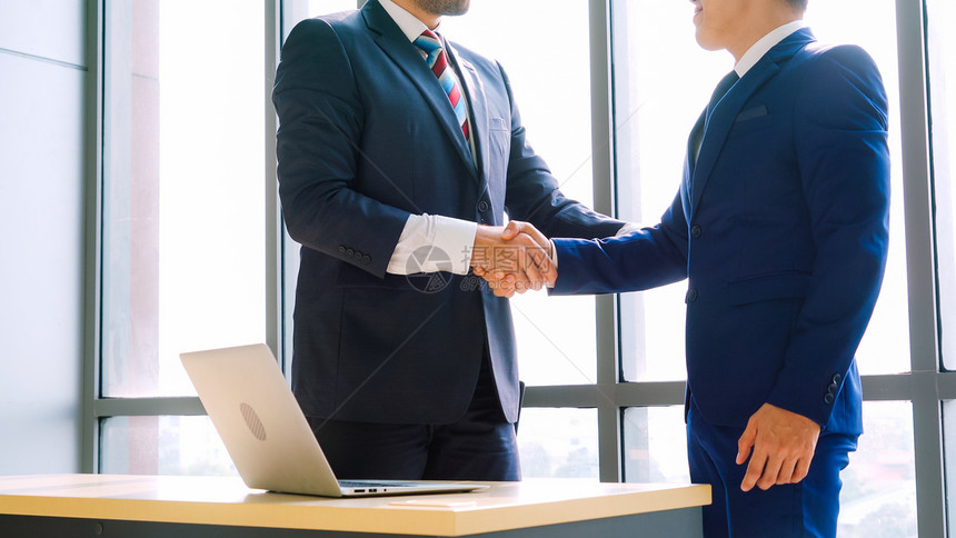 商业界人士在公司办室握手表现出对财务交易合同的专业协议图片