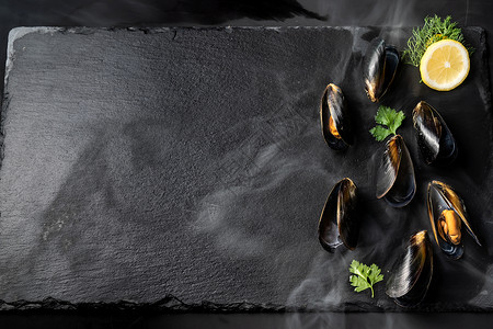 黑贝类和柠檬在石板上新鲜的海食品和欧洲烹饪美食的概念图片