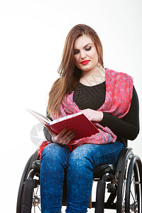 学习和阅读概念残疾和坐轮椅的年轻残疾妇女阅读书坐轮椅的年轻残疾妇女阅读书背景图片