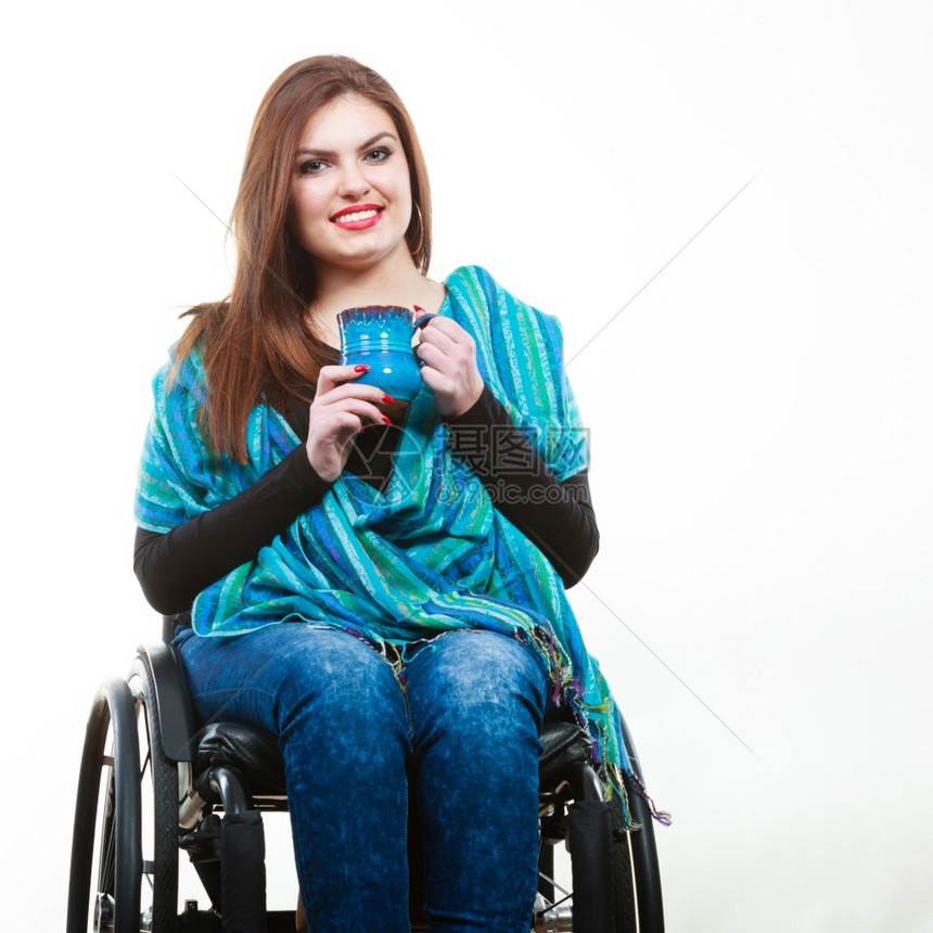 Dronk饮料残疾快乐概念微笑残疾女士年轻孩坐在轮椅上拿着蓝色杯子微笑残疾女士图片