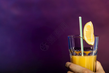 酒派对概念某人拿着一杯果汁某人举起杯子橙汁背景图片