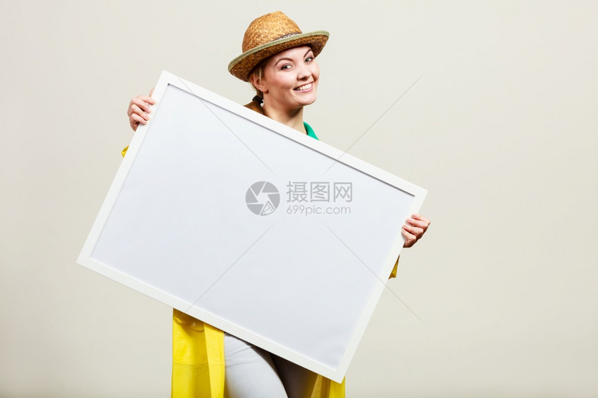 戴着太阳帽和雨衣的快乐女人拿着白板的快乐女人拿着白板的快乐女人图片