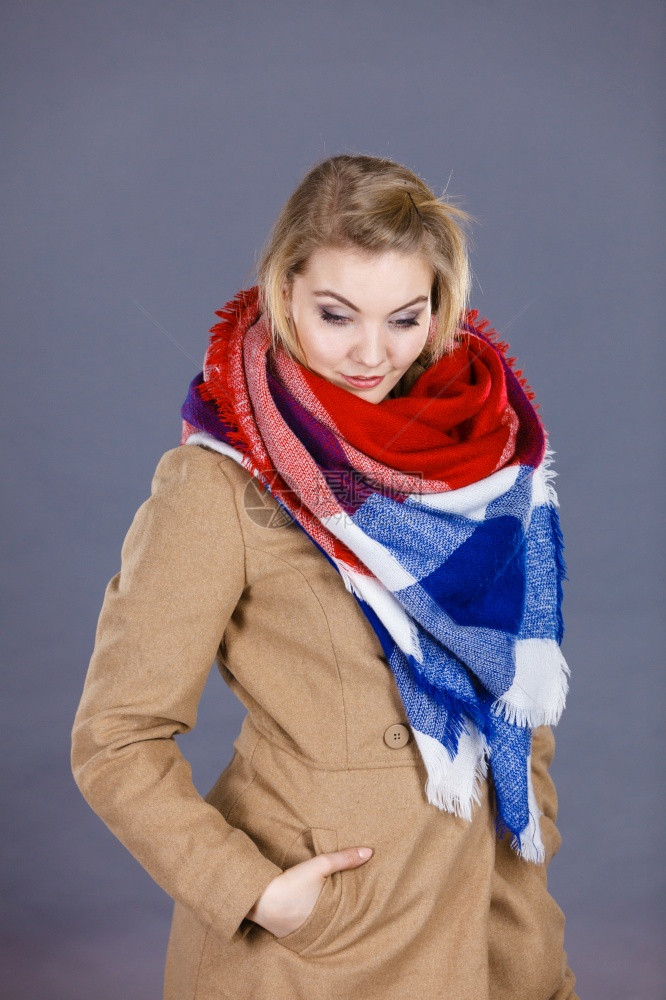 穿着浅棕色大衣和彩围巾的妇女冬季时装概念穿着彩色围巾的妇女穿着浅褐色大衣和彩围巾的妇女图片
