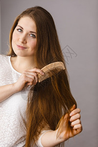 美发和清晨型概念快乐的女子梳她长深棕色头发快乐的女子梳她头发图片