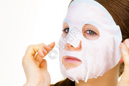 妇女用面罩蒙在脸上白的照顾皮肤美容处理皮肤用面罩蒙在脸上的用面罩遮在脸上的背景图片