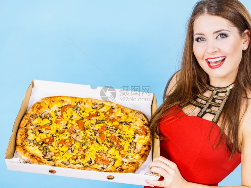 年轻人意大利烹饪概念年轻女在盒子里拿着热的新鲜大披萨在蓝色上美味快餐送货服务女在盒子里拿着大披萨图片